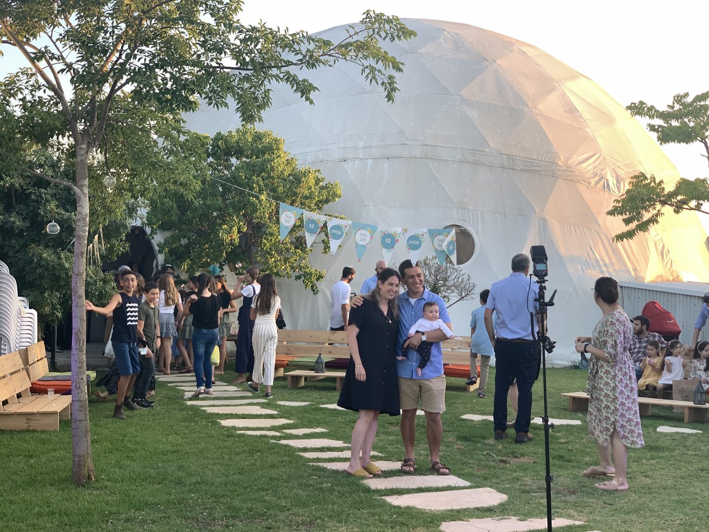 A gathering at Havat HaChaim, the great dome glowing in the evening light